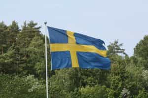 Swedish flag with trees in the background.